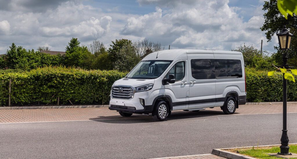 A school minibus parked on a leafy street.
