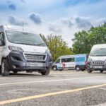 Several school minibuses parked in a school car park.