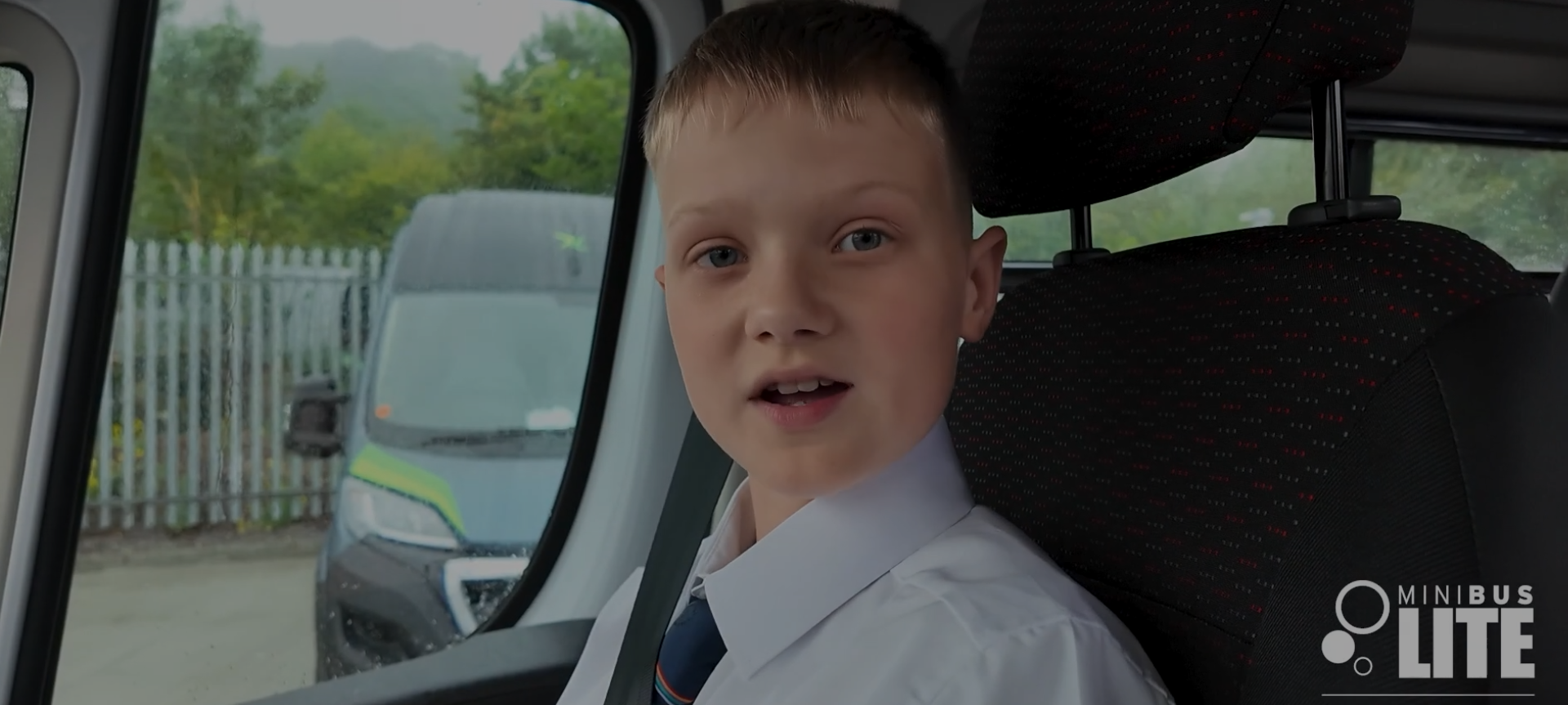 Schoolboy sitting inside a minibus